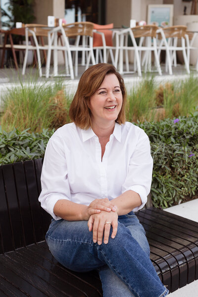 Ilse Vonk, an experienced fractional and interim CEO, smiling while sitting on a bench.
