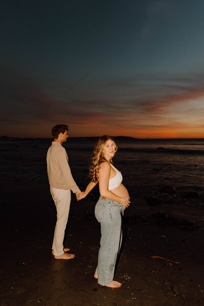 pregnant woman and  man flash photo on a beach