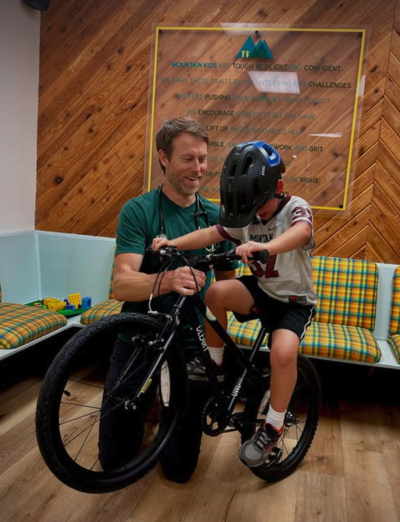 Picture of Dr. Hastings gifting a bike and helmet to a patient in the waiting room of MKP