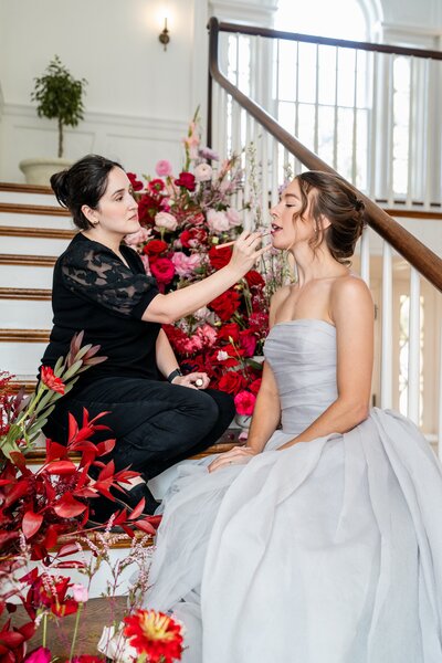 Kiley Smith a makeup artist is wearing a black top and applying makeup to a brides face in Middleburg Virginia