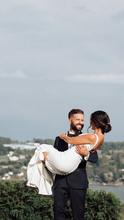 Groom picking up his bride at Crispin Hill with a rainbow