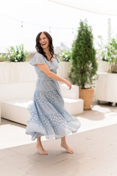 A woman looks happy while wearing a long blue dress