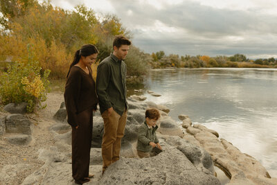 A close up of a woman wearing a cowboy hat. Standing behind her, slightly blurred is her boyfriend smiling at the camera.