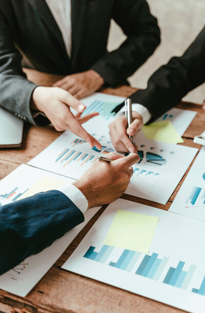 Financial consulting services in Dallas during a meeting focused on international trade solutions. Consultants are collaboratively analyzing statistics and discussing strategies to address global market challenges.