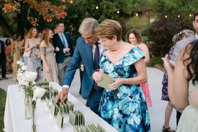 Bride's parents grabbing their handwritten letters from the couple at this micro wedding reception in Colorado