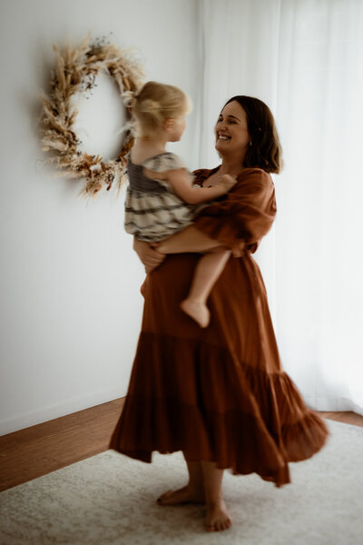 mother and daughter spinning around in family photos