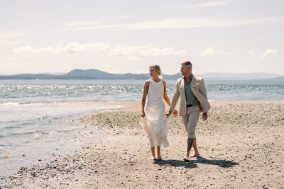 Bride & Groom walking on the PNW shoreline on their Puget Sound elopement