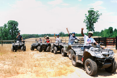 Group of John Deere four wheeler riders cheer and have fun during a unique group experience in North Georgia