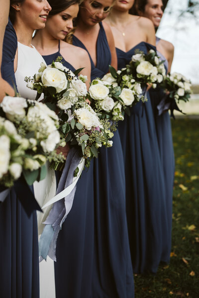 Bride & groom kissing at sweetheart table with cascading greenery in tented reception featured on Rustic Wedding Chic