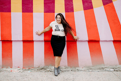 smiling woman with colorful wall