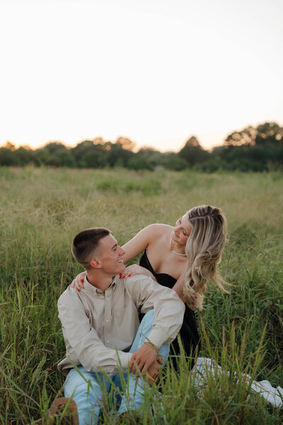 Couple embracing by the lake at sunset under moss-covered trees during a romantic waterfront session in Alabama — EC Photography