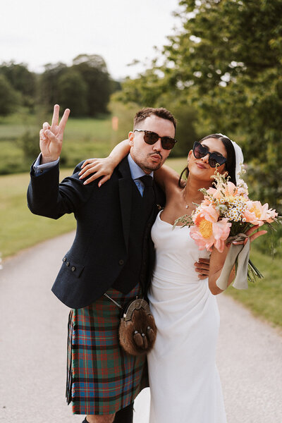 bride wearing white lace dress hugging groom both with huge smiles fun aberdeen wedding photography