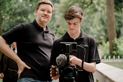 Kevin Christensen, video producer, directing a shoot on location while wearing a black polo.