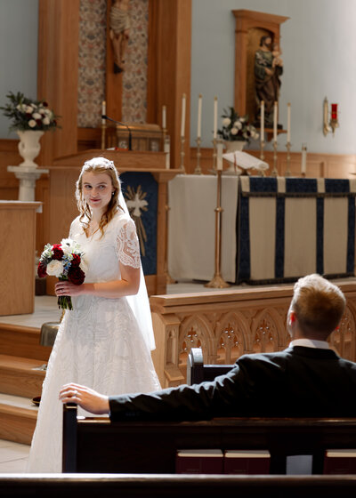 a catholic couple poses at st. catherine's in columbia tennessee for a romantic catholic portrait after their traditional roman catholic wedding Mass.