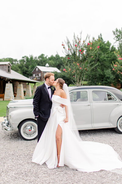 Couple in front of a classic car at their wedding reception at The Barn at Shady Lane