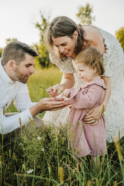 family picks flowers with toddler daughter during photo session