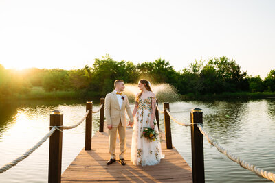 a bride and groom walking hand in hand down a alley way in downtown abilene, texas looking at each other laughing while Shelly Voss documents their wedding.