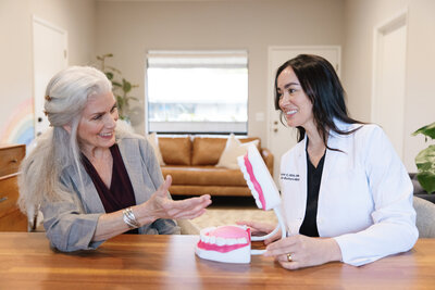 Orofacial Myofunctional Therapist interacting with an adult patient in an office setting.