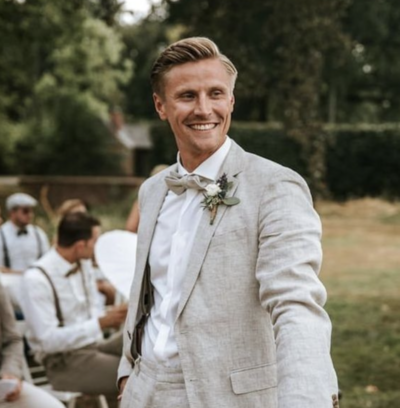Groom wearing cream tux outside