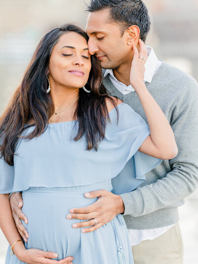 Husband gently pulling pregnant woman close in Massachusetts Maternity Photography session
