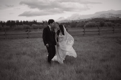 black and white photo of couple walking back from sunset