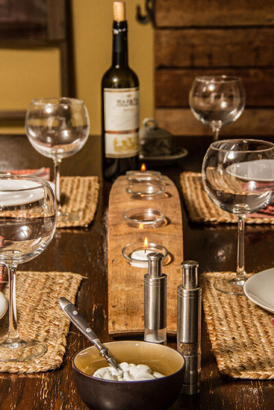 Place marketing photo dining table set with wine glasses woven place mats candles Gatos Trail Ranch