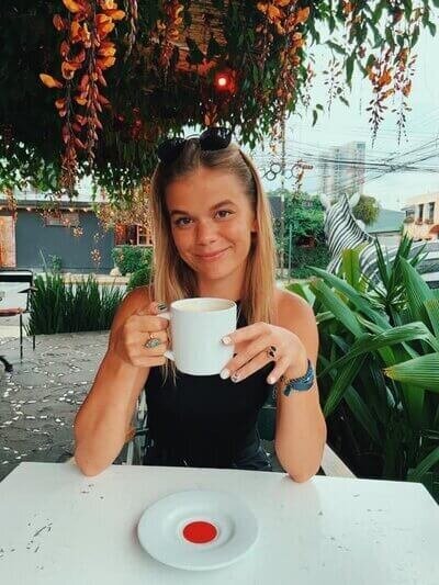 Head shot of Hannah Ruse drinking coffee