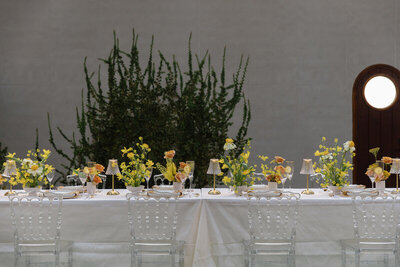 A yellow tablescape at an indoor wedding venue