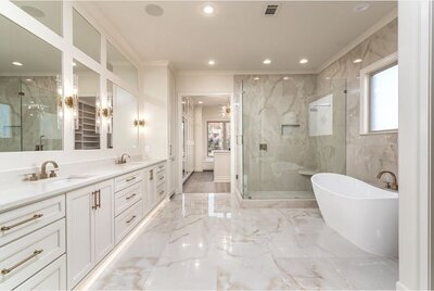 Remodeled white bathroom with glossy, white marble tile.