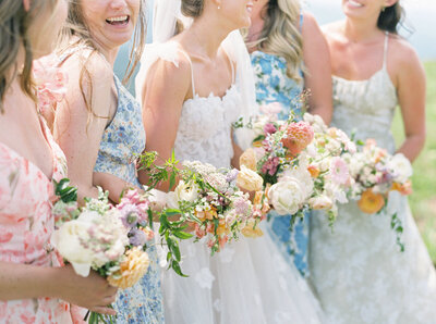 A bride and her bridesmaids hold pastel wildflowers in Vail.