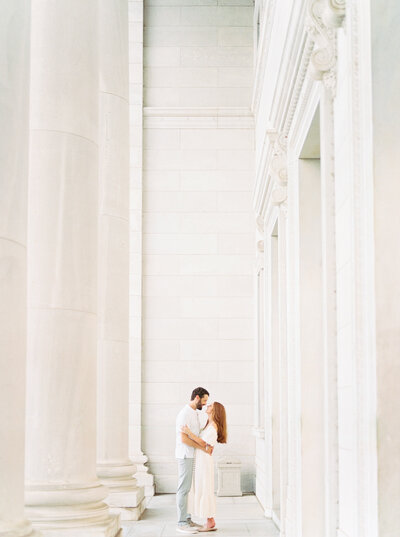 Husband and wife embrace amid white stone at the Arkansas State Capitol building in Little Rock