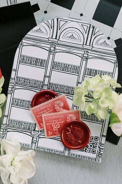 custom venue illustration printed on invitation details card styled with a red wax seal, flowers and vintage stamps