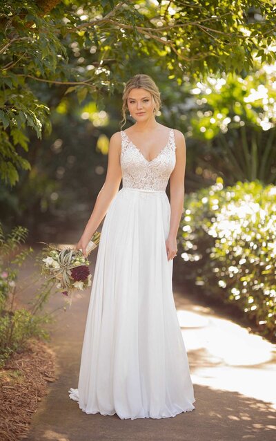 LACE AND CHIFFON WEDDING DRESS WITH DETACHABLE BELT Relaxed yet glamorous, Style D3224 from Essense of Australia embodies casual summer beauty. With a classic V-neckline and wide-set straps, the layers of the lace bodice create an element of sheerness–while a subtle sparkle throughout gives you a dewy shine. The texture of the laces give the design a fresh and youthful feel, which perfectly complement the detachable belted bow at the waist. A low V-back with an organic lace edge shows of your sun-kissed skin, while the matte chiffon skirt is modern, comfortable and oh-so breezy. This gown zips closed beneath a small row of fabric-covered buttons for a final touch of classic inspiration.