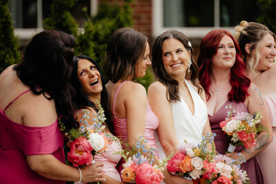 Bride posing with her bridesmaids and their bouquets.