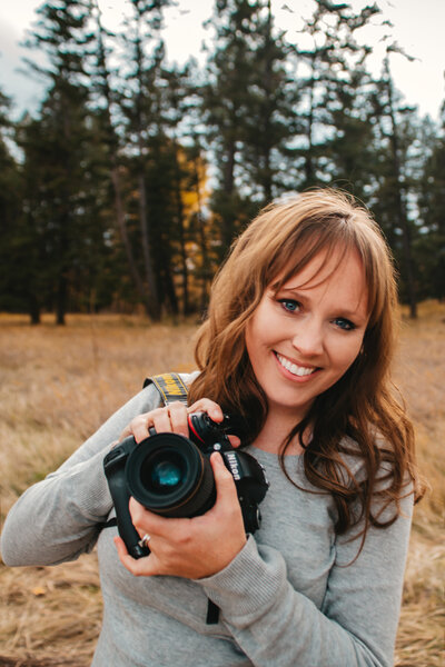 Photographer Lexi Richardson smiles with her camera in Glacier National Park in western Montana.
