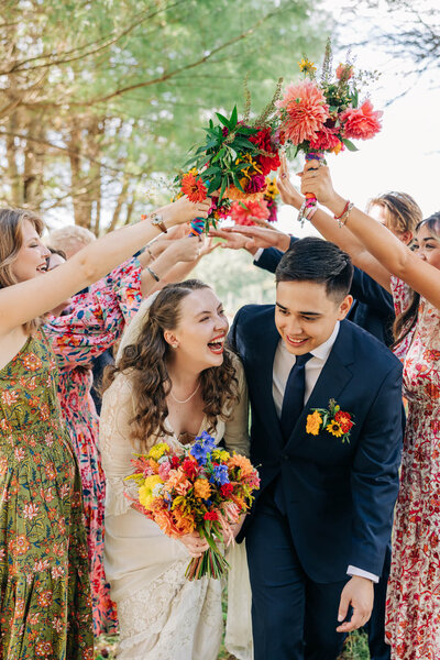 Couple smiling at each other while surrounded by their friends cheering
