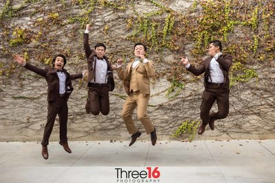 Groom and his Groomsmen jump for joy celebrating the wedding ceremony