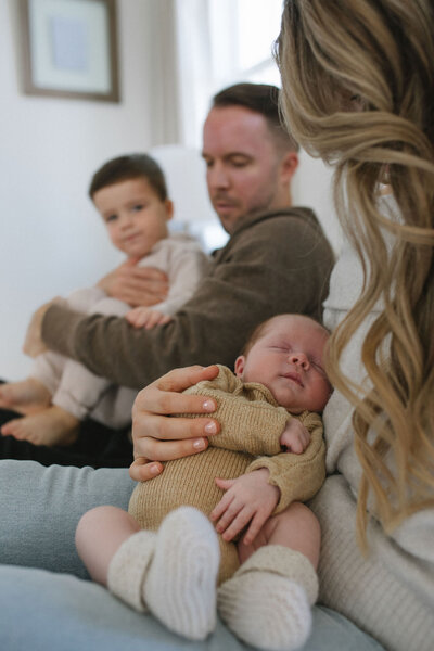family of four together at home after youngest brother is born
