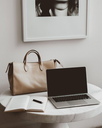 Laptop, notebook, and leather tote on marble table – Effortless Web Design