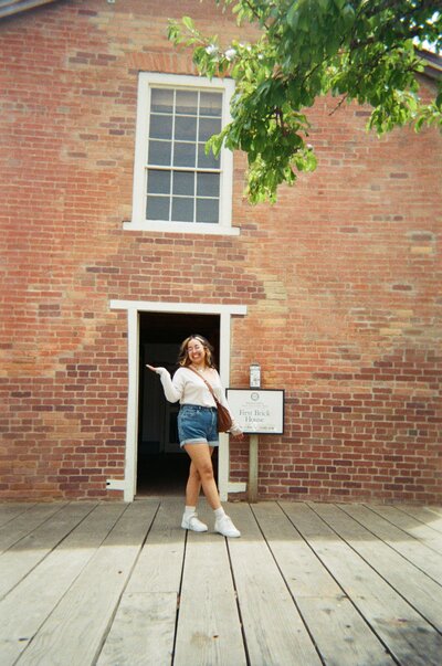 Virtual Assistant Vanessa standing in the middle of door in a brick house.