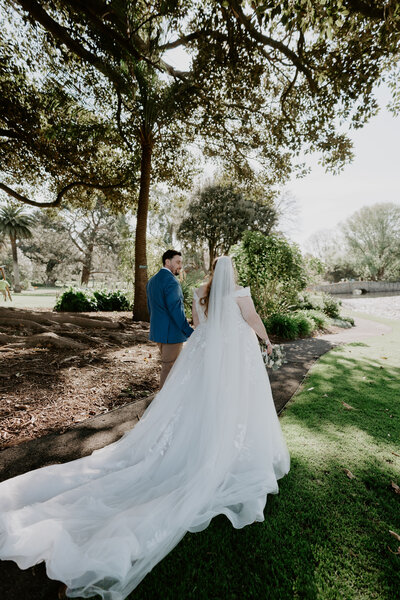 Newly wed bride and groom walking through Warrnambool botanical gardens