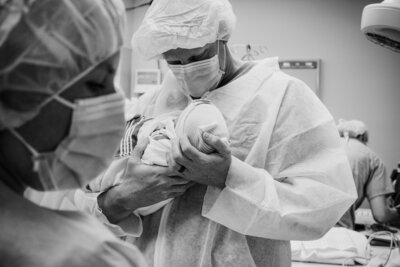 Father gazes over his newborn after a c-section birth in OKC.