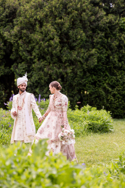 Captured in vibrant colors, this stunning photo showcases Divya and Dhruv during their traditional Indian wedding ceremony. Dressed in exquisite attire, the couple performs rituals surrounded by rich, decorative elements and floral arrangements that highlight the cultural significance and beauty of Indian weddings. This image is a beautiful representation of love and tradition, making it a perfect source of inspiration for couples planning a culturally rich and visually breathtaking wedding.