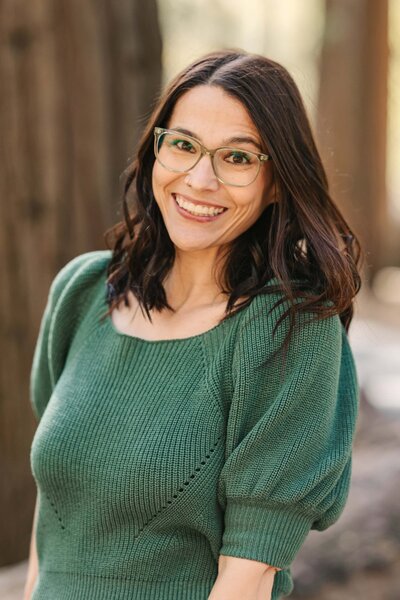 Photo of the head photographer, dana, smiling at the camera during golden hour