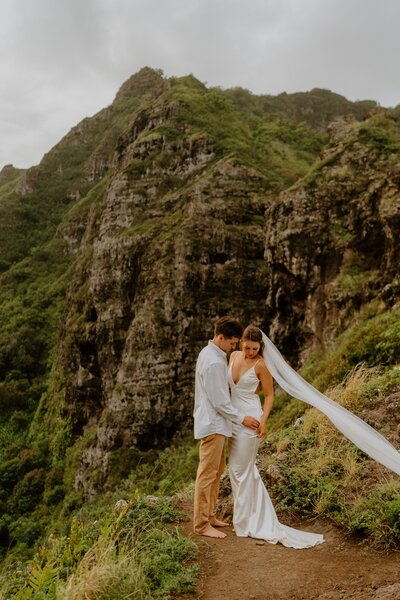 bride and groom standing on cliff edge