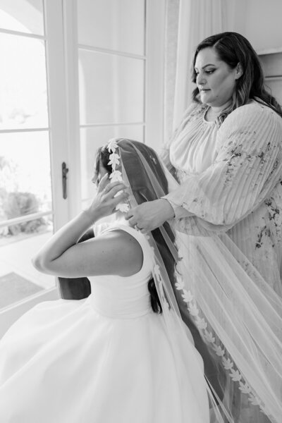 bride putting on her veil at terranea resort, black and white editorial image