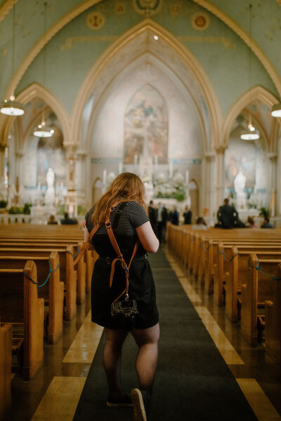 wedding photographer taking photos in historic, ornate church cathedral