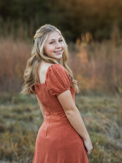 girl in orange dress posing for family photos at westcreek reservation Cleveland family photography