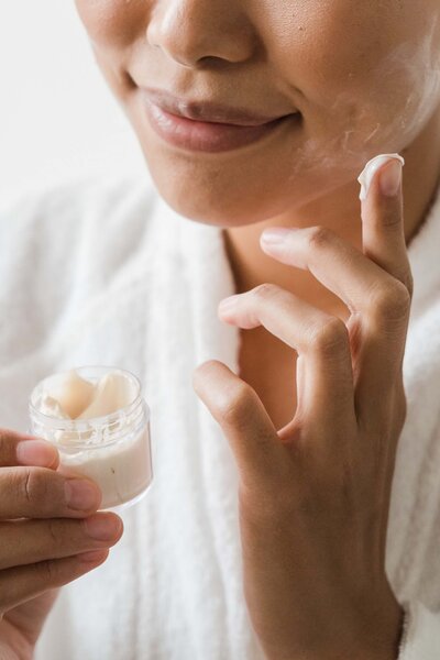 woman putting skin care product on face