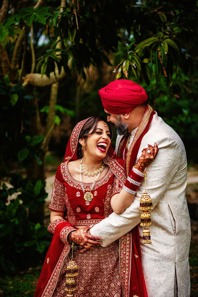 A bride wearing a heavily embellished lehenga and intricate henna designs on her hands. Captured by Shannon, an Orlando, Florida Indian Wedding Photographer.